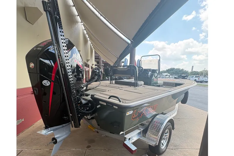 Slide: The Image of A 2025 Mako 18 Pro Skiff Backwater Edition on a trailer under an awning. - 4