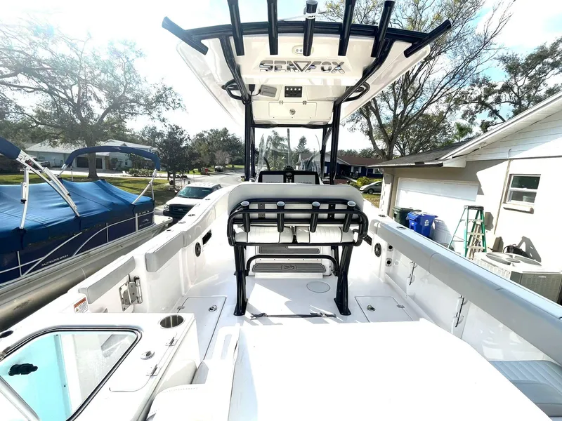 Slide: The Image of 2023 Sea Fox 268 Commander boat interior with seating and console, parked outdoors. - 19