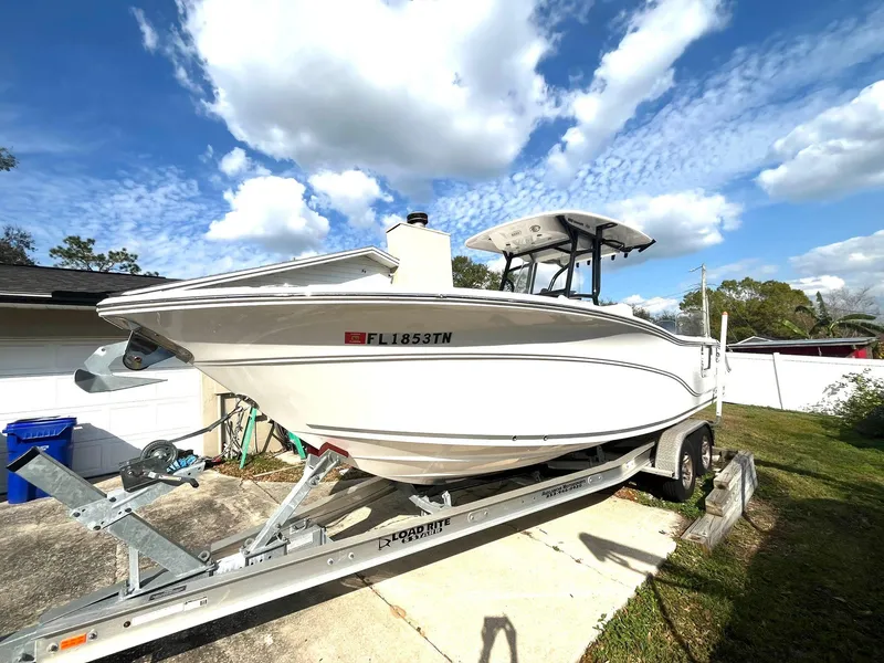 Slide: The Image of 2023 Sea Fox 268 Commander boat on trailer under a blue sky with clouds. - 2