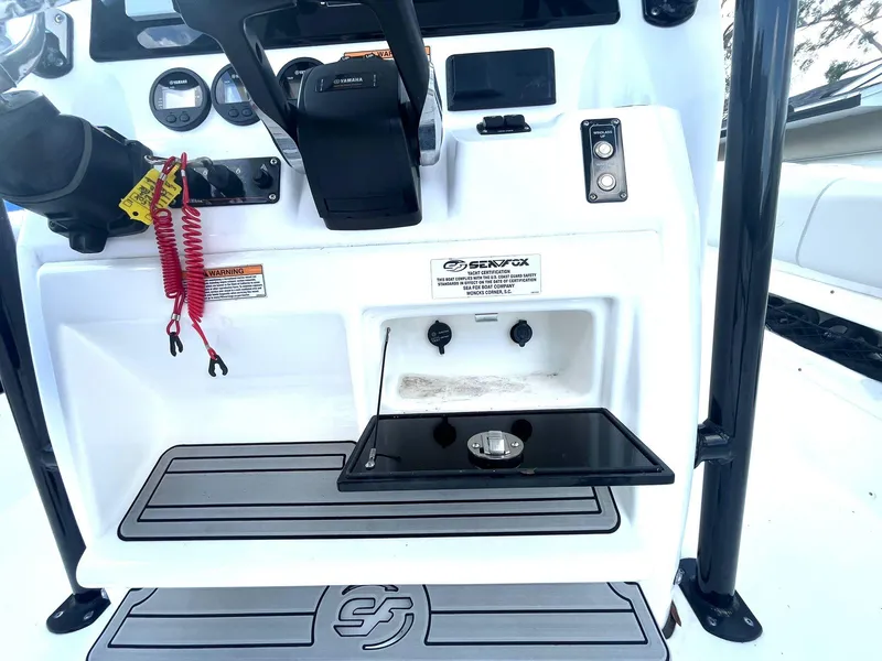 Slide: The Image of 2023 Sea Fox 268 Commander boat dashboard with controls and storage compartment. - 25