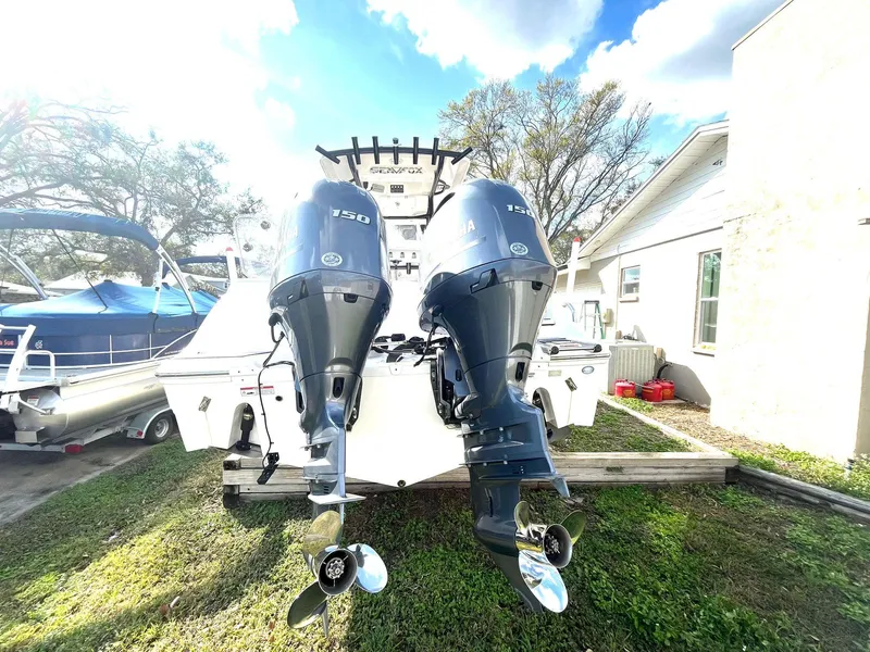 Slide: The Image of 2023 Sea Fox 268 Commander with twin outboard engines, parked outdoors. - 8