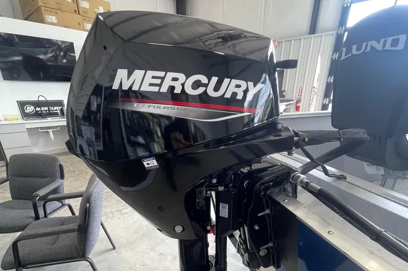 Slide: The Image of 2025 Lund 1400 Fury SS with Mercury outboard motor in showroom setting. - 5