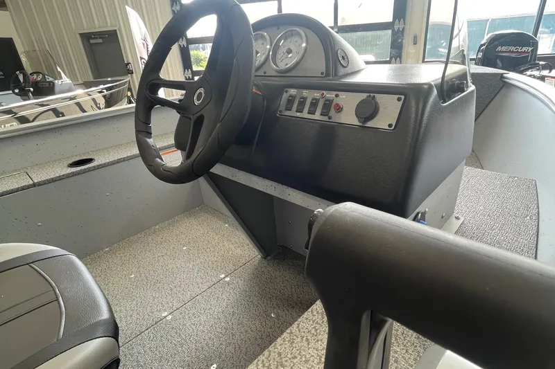 Slide: The Image of 2025 Lund 1400 Fury SS boat interior with steering wheel and control panel. - 7