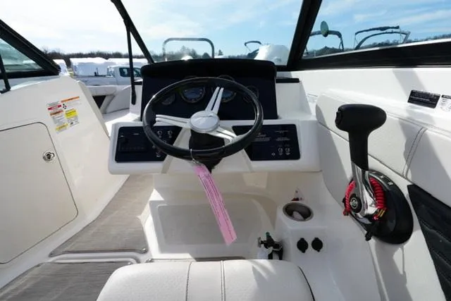Slide: The Image of 2023 Sea Ray SPX 210 boat cockpit with steering wheel and control panel. - 10