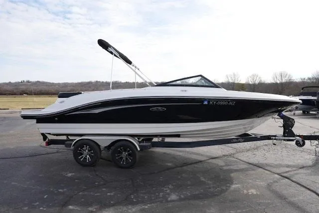 Slide: The Image of 2023 Sea Ray SPX 210 boat on trailer, black and white design, parked outdoors. - 3