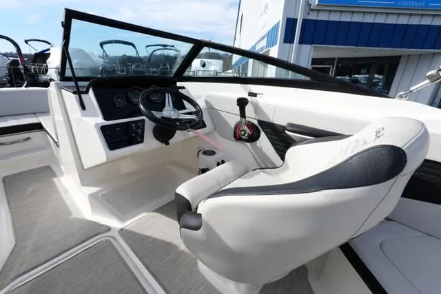 Slide: The Image of 2023 Sea Ray SPX 210 boat interior with steering wheel and captain's seat. - 9