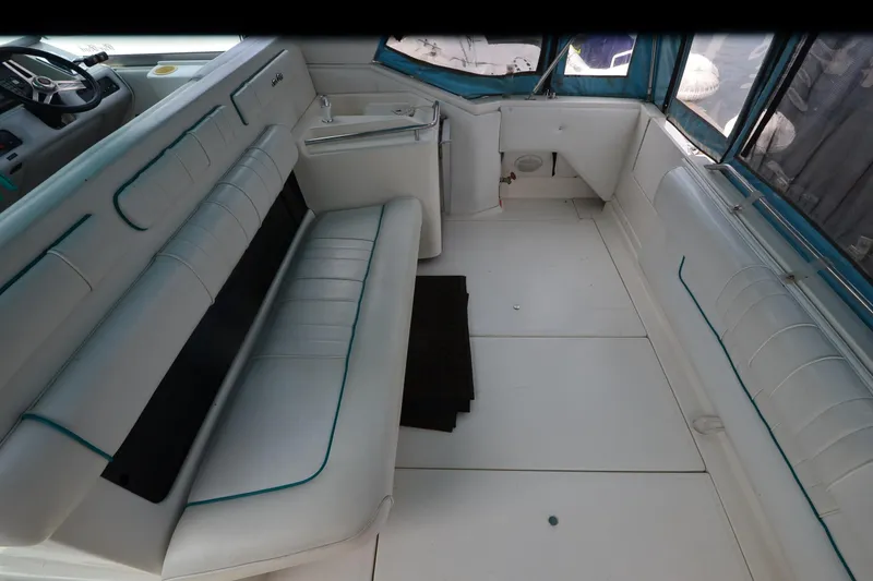 Slide: The Image of 1994 Sea Ray 330 Sundancer interior with white seating and steering area. - 14