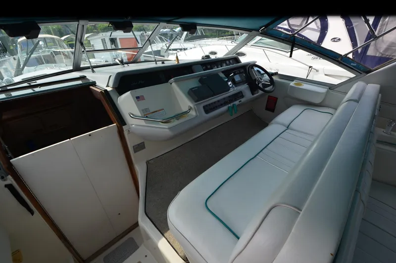 Slide: The Image of 1994 Sea Ray 330 Sundancer cockpit with steering wheel and seating area. - 16