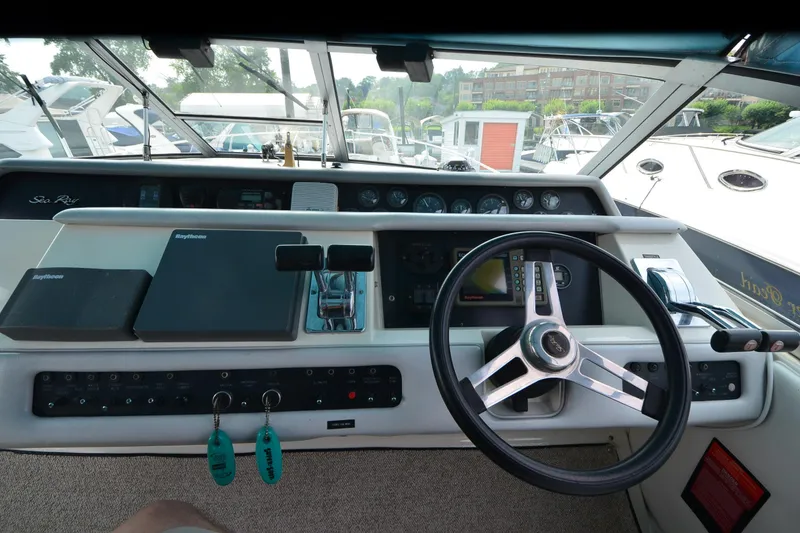 Slide: The Image of 1994 Sea Ray 330 Sundancer helm with steering wheel, gauges, and navigation equipment. - 17