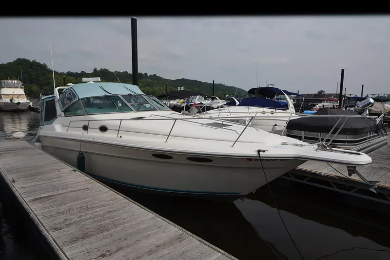 Slide: The Image of 1994 Sea Ray 330 Sundancer docked at marina, surrounded by other boats. - 2