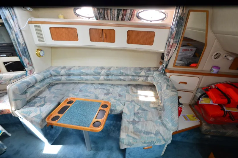 Slide: The Image of Interior of 1994 Sea Ray 330 Sundancer with cozy seating and storage cabinets. - 21