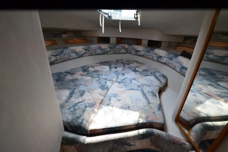 Slide: The Image of 1994 Sea Ray 330 Sundancer cabin interior with patterned bedding and mirrored wall. - 23