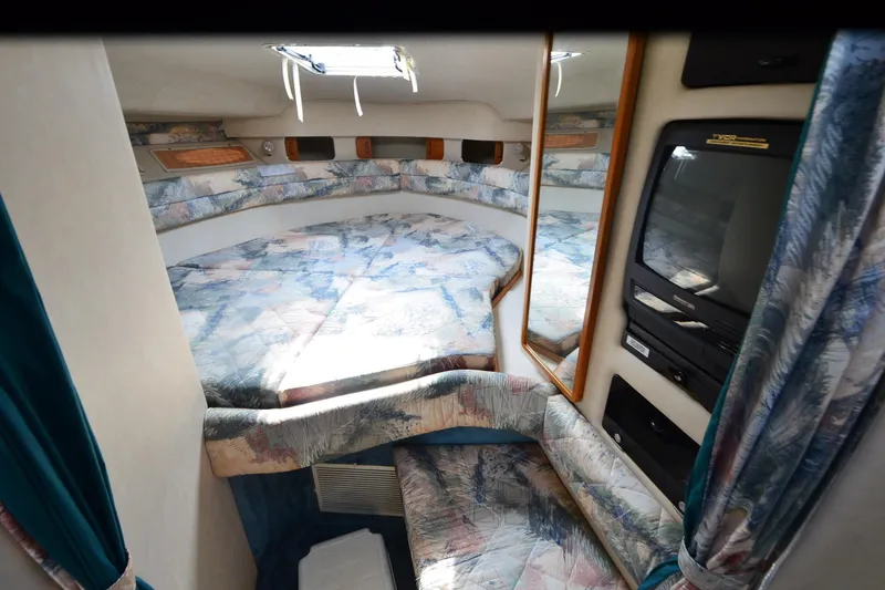 Slide: The Image of Interior of 1994 Sea Ray 330 Sundancer with cozy bed and TV setup. - 24