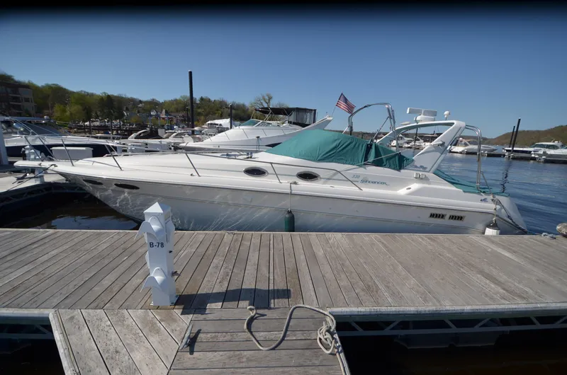 Slide: The Image of 1994 Sea Ray 330 Sundancer docked at marina with American flag, sunny day. - 3