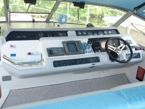 Slide: The Image of 1994 Sea Ray 330 Sundancer helm with steering wheel and navigation instruments. - 8
