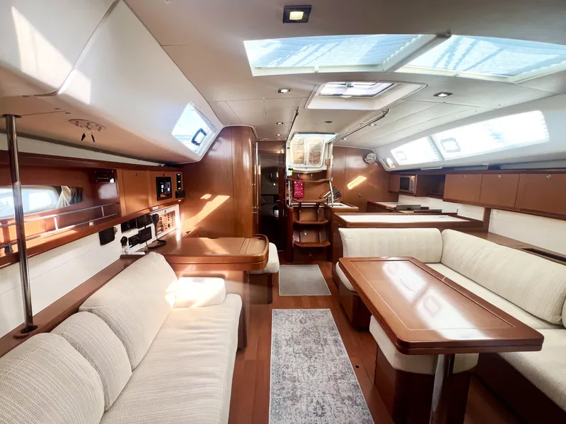 Slide: The Image of Interior of a 2008 Beneteau 46 yacht, featuring elegant wood finishes and comfortable seating. - 12