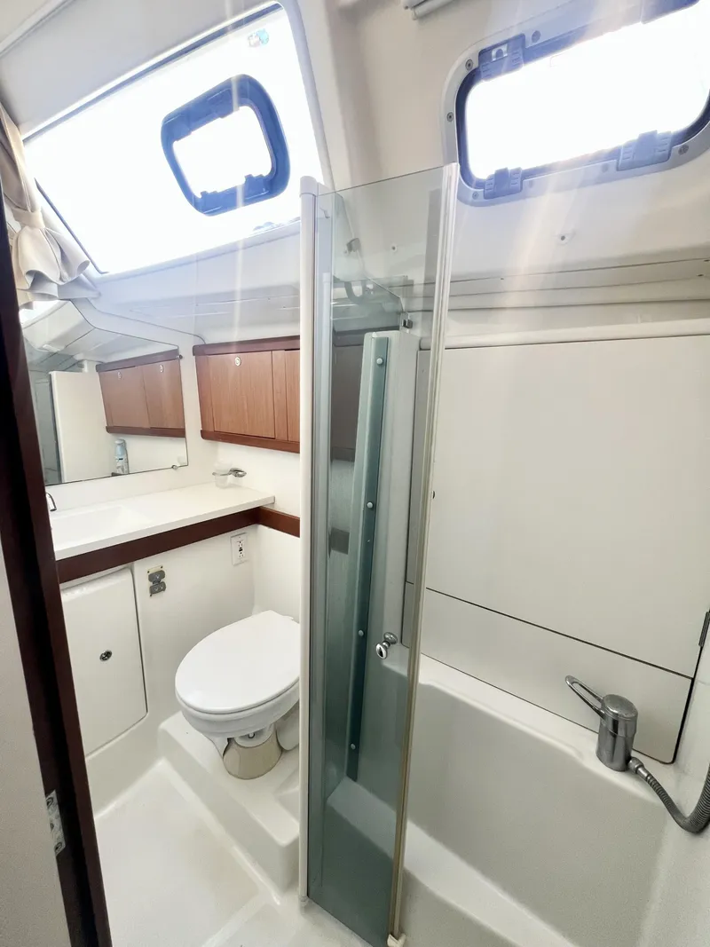 Slide: The Image of 2008 Beneteau 46 yacht bathroom with shower, toilet, and wooden cabinets. - 18