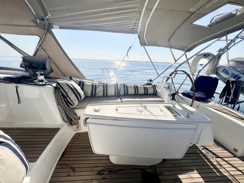 Slide: The Image of 2008 Beneteau 46 yacht cockpit with striped cushions, wooden deck, and ocean view. - 5