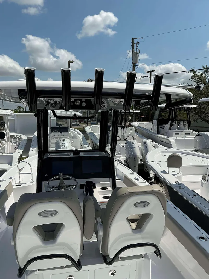Slide: The Image of 2025 Sportsman 267 Masters boat interior with dual seats and control panel under a clear sky. - 16