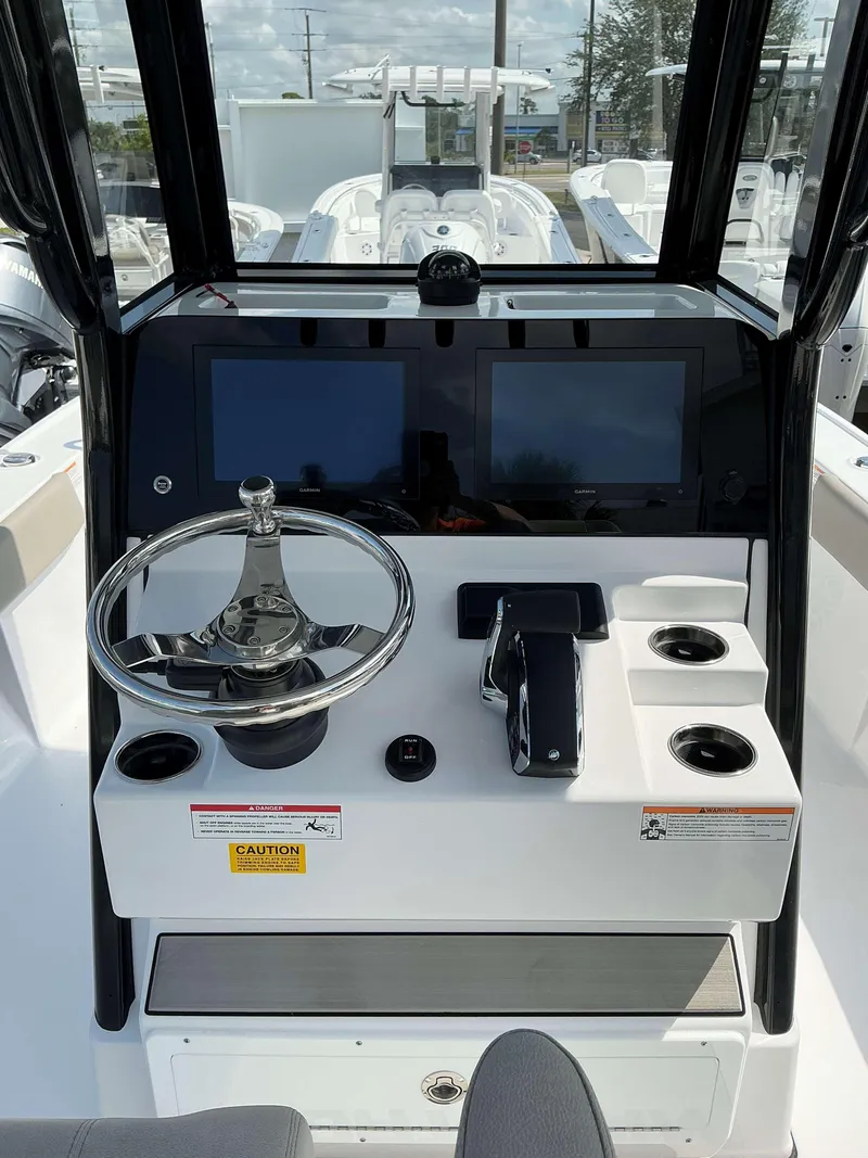 Slide: The Image of 2025 Sportsman 267 Masters boat dashboard with steering wheel and dual screens. - 6