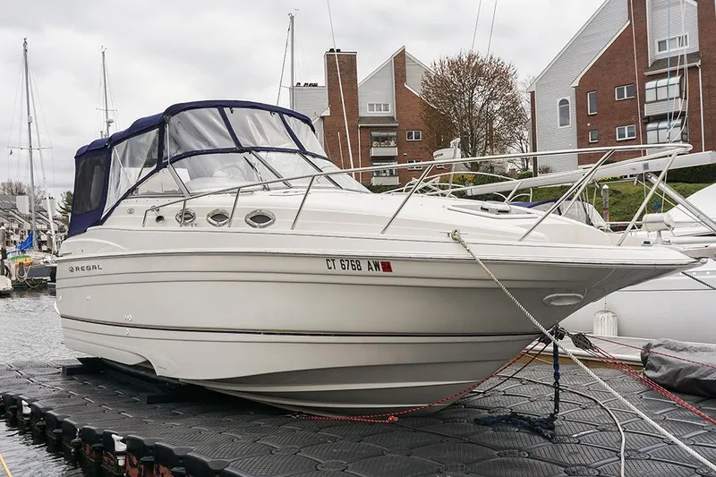 The Image of 2000 Regal Commodore 2660 boat docked at marina, featuring sleek design and covered cockpit. - 0
