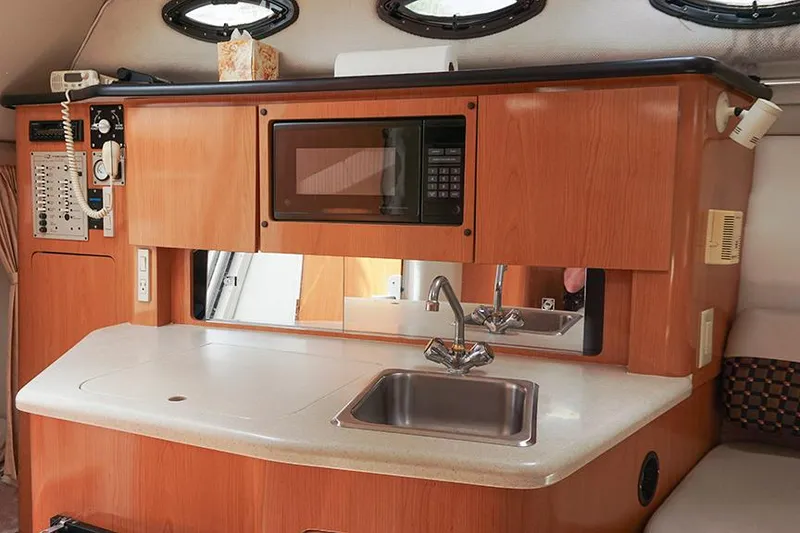 Slide: The Image of Interior of 2000 Regal Commodore 2660 boat with kitchenette, sink, and microwave. - 26