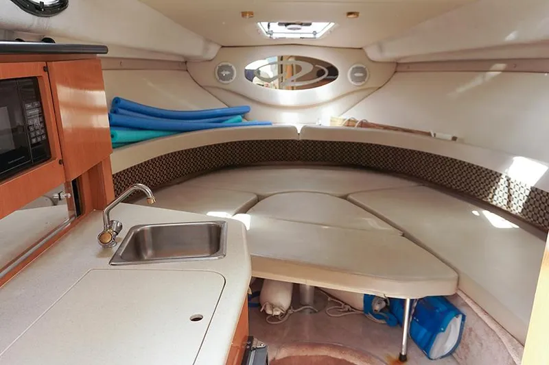 Slide: The Image of Interior of 2000 Regal Commodore 2660 boat with kitchenette and seating area. - 27