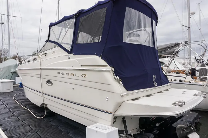 Slide: The Image of 2000 Regal Commodore 2660 boat with blue canopy docked at marina. - 3