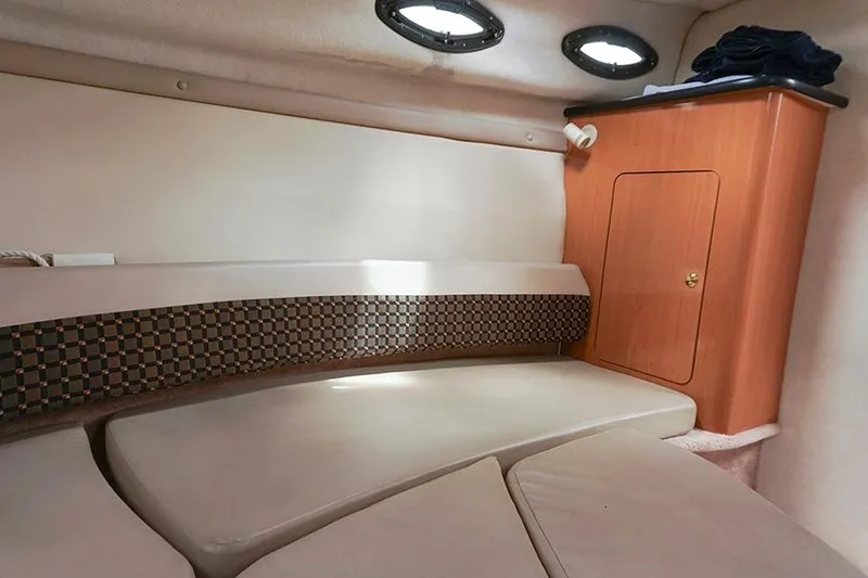 Slide: The Image of Interior cabin of 2000 Regal Commodore 2660 boat with cushioned seating and wooden cabinet. - 31