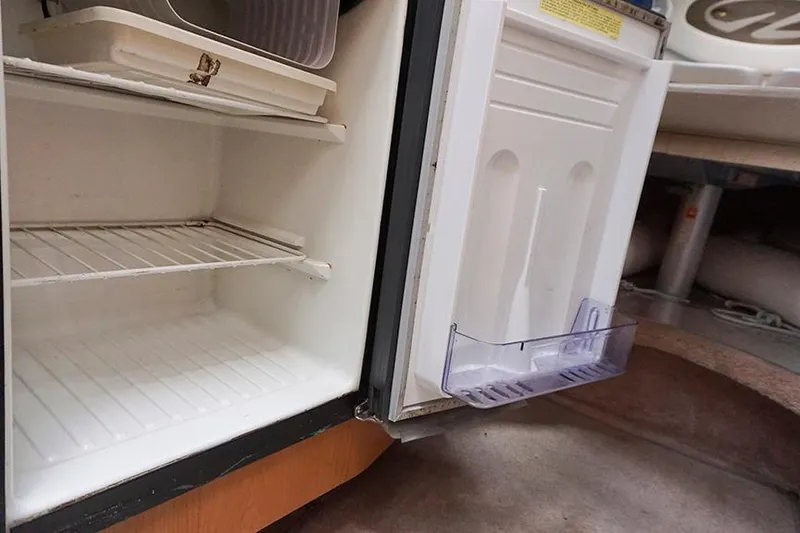 Slide: The Image of Open refrigerator inside a 2000 Regal Commodore 2660 boat, showing empty shelves. - 39