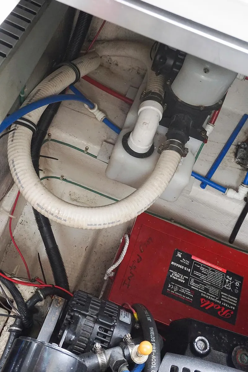 Slide: The Image of Engine compartment of a 2000 Regal Commodore 2660 boat, showing hoses and battery. - 45