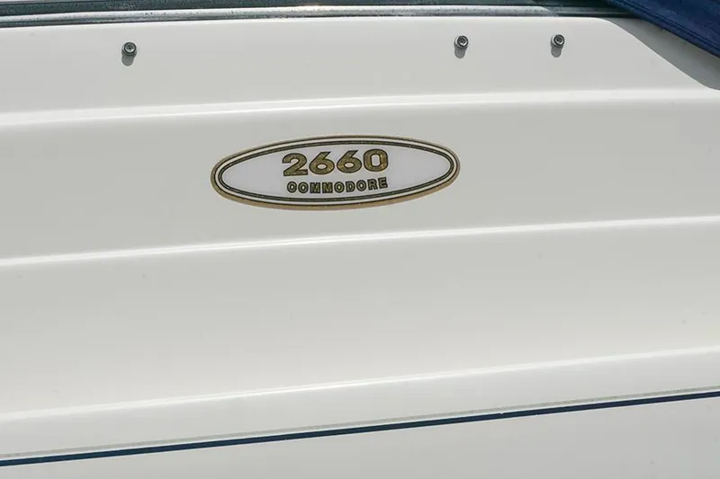 Slide: The Image of 2000 Regal Commodore 2660 boat emblem on white surface. - 49