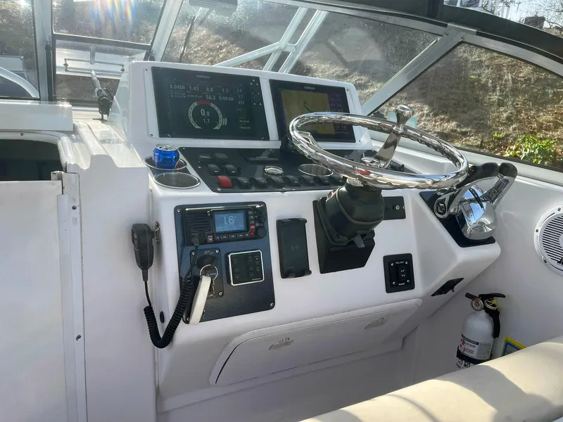 Slide: The Image of 2003 Pro-Line 30 WALKAROUND boat dashboard with steering wheel and control panel. - 11