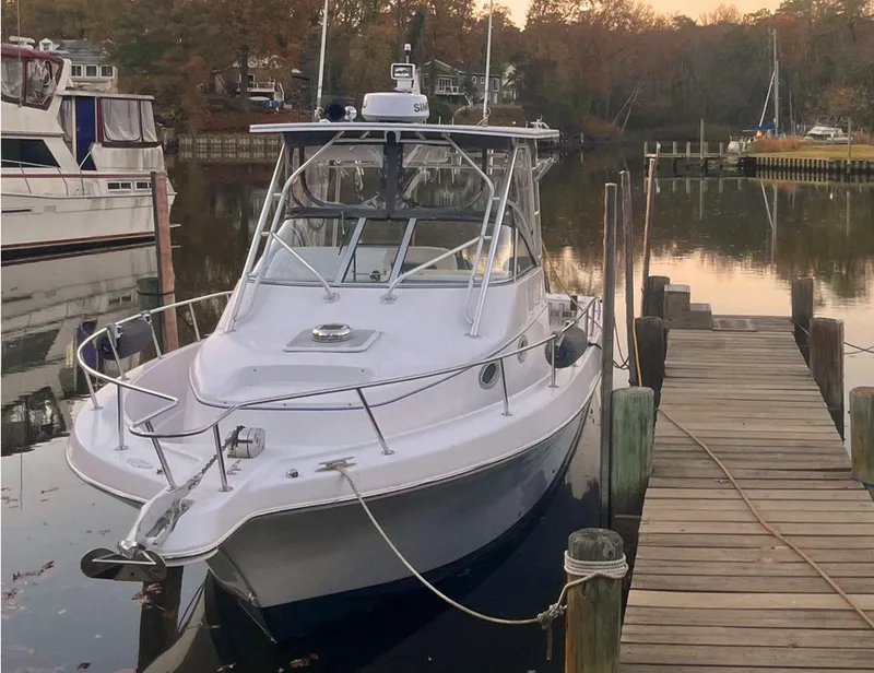 Slide: The Image of 2003 Pro-Line 30 Walkaround boat docked in a serene marina setting. - 15