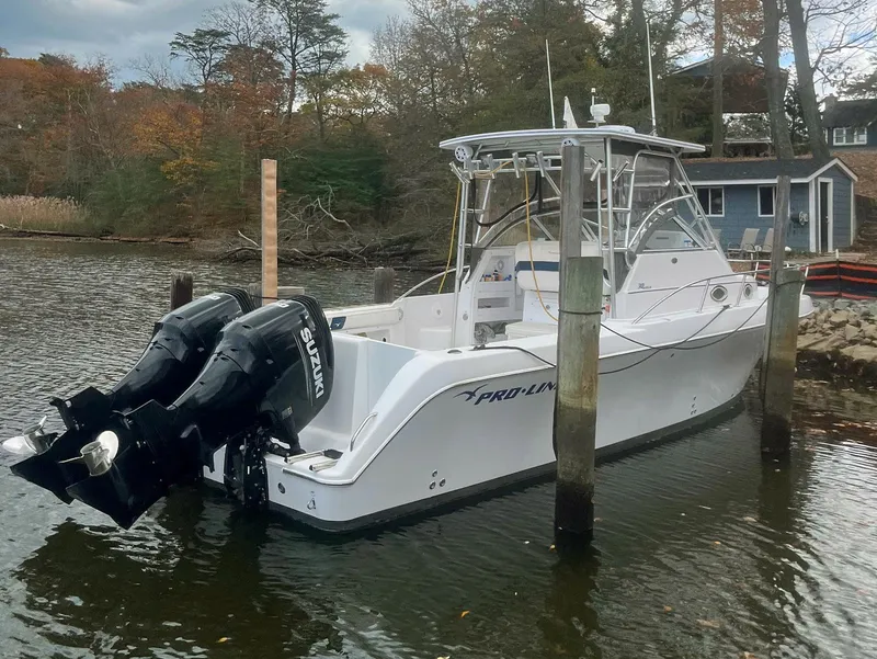 Slide: The Image of 2003 Pro-Line 30 Walkaround boat docked with dual Suzuki outboard engines. - 16