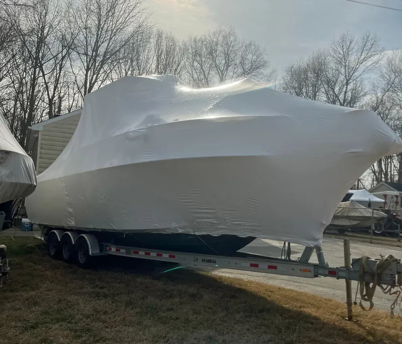 Slide: The Image of 2003 Pro-Line 30 WALKAROUND boat covered on trailer, parked outdoors. - 17