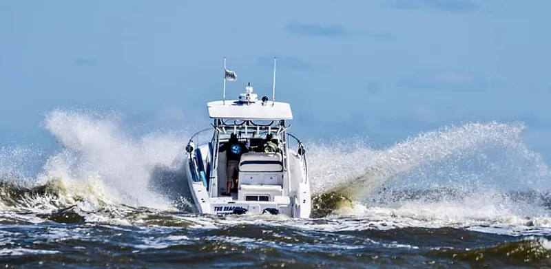 Slide: The Image of 2003 Pro-Line 30 WALKAROUND boat navigating through ocean waves. - 18