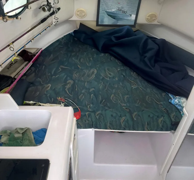 Slide: The Image of 2003 Pro-Line 30 WALKAROUND cabin interior with bed and fishing rods. - 5