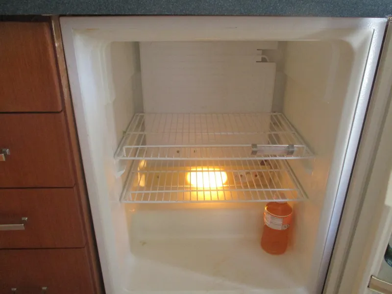 Slide: The Image of Empty refrigerator with a single orange bottle inside, aboard a 1997 Ocean Yachts 40 Super Sport. - 34