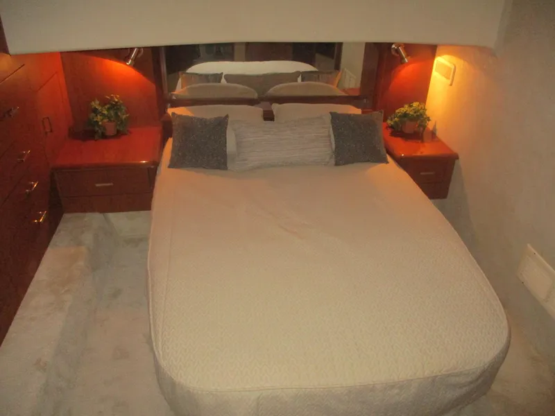 Slide: The Image of 1997 Ocean Yachts 40 Super Sport bedroom with cozy bed, wooden cabinets, and soft lighting. - 37