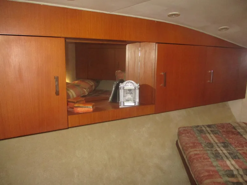 Slide: The Image of 1997 Ocean Yachts 40 Super Sport interior with wooden cabinets and cozy bedding. - 44