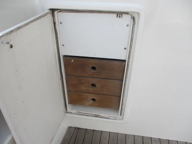 Slide: The Image of 1997 Ocean Yachts 40 Super Sport storage compartment with wooden drawers and open door. - 6