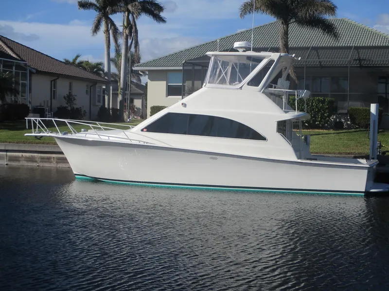The Image of 1997 Ocean Yachts 40 Super Sport boat docked near waterfront homes. - 0