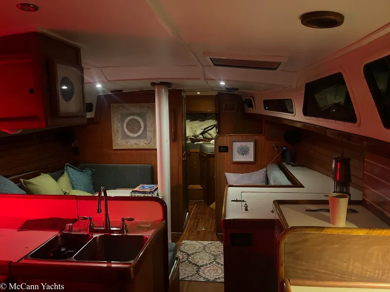 Slide: The Image of 1973 Challenger 40 yacht interior with cozy seating, kitchenette, and ambient lighting. - 12