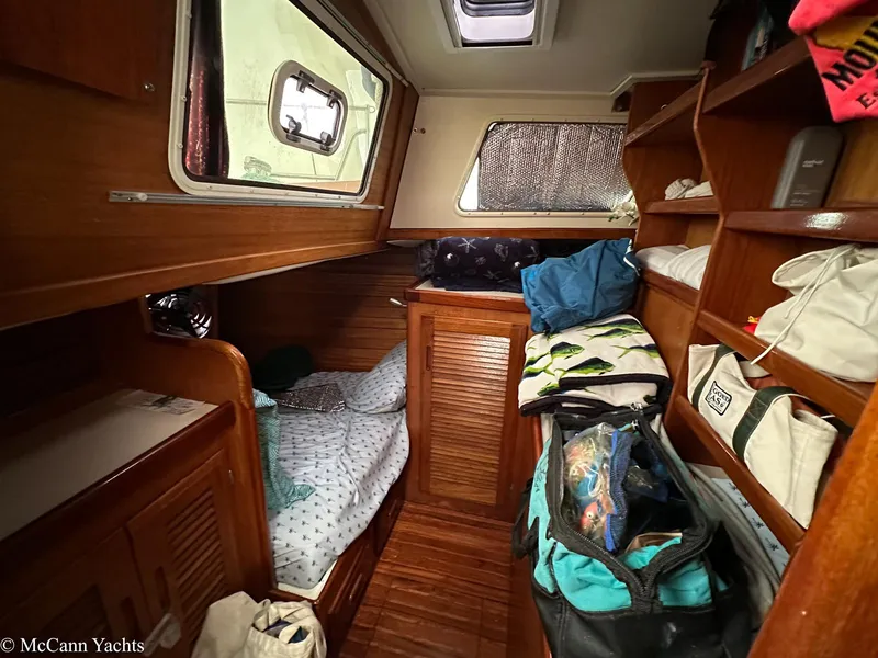 Slide: The Image of 1973 Challenger 40 yacht cabin with wooden interior, bed, and storage shelves. - 17