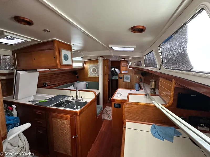 Slide: The Image of Interior of a 1973 Challenger 40 yacht, featuring a cozy kitchen and wooden cabinetry. - 19