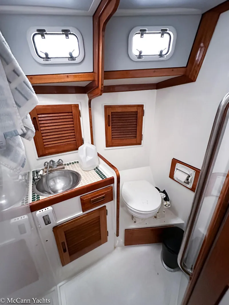 Slide: The Image of 1973 Challenger 40 yacht bathroom with wooden accents, sink, and toilet. - 27