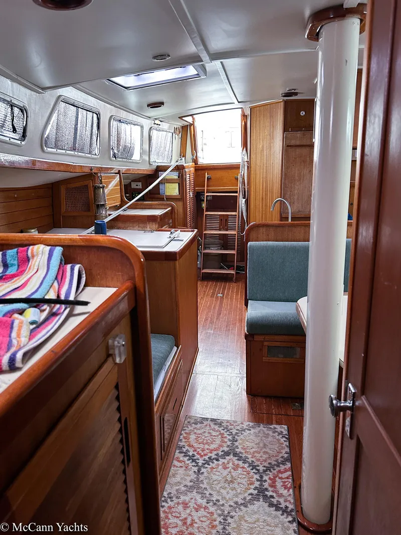 Slide: The Image of Interior of a 1973 Challenger 40 yacht, featuring wood finishes and cozy seating. - 29