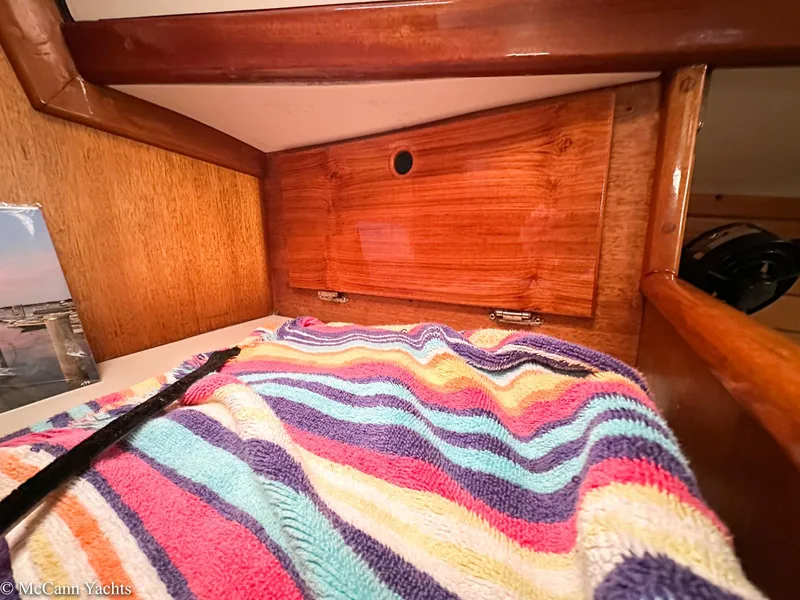Slide: The Image of 1973 Challenger 40 yacht interior with colorful striped blanket and wooden cabinetry. - 32