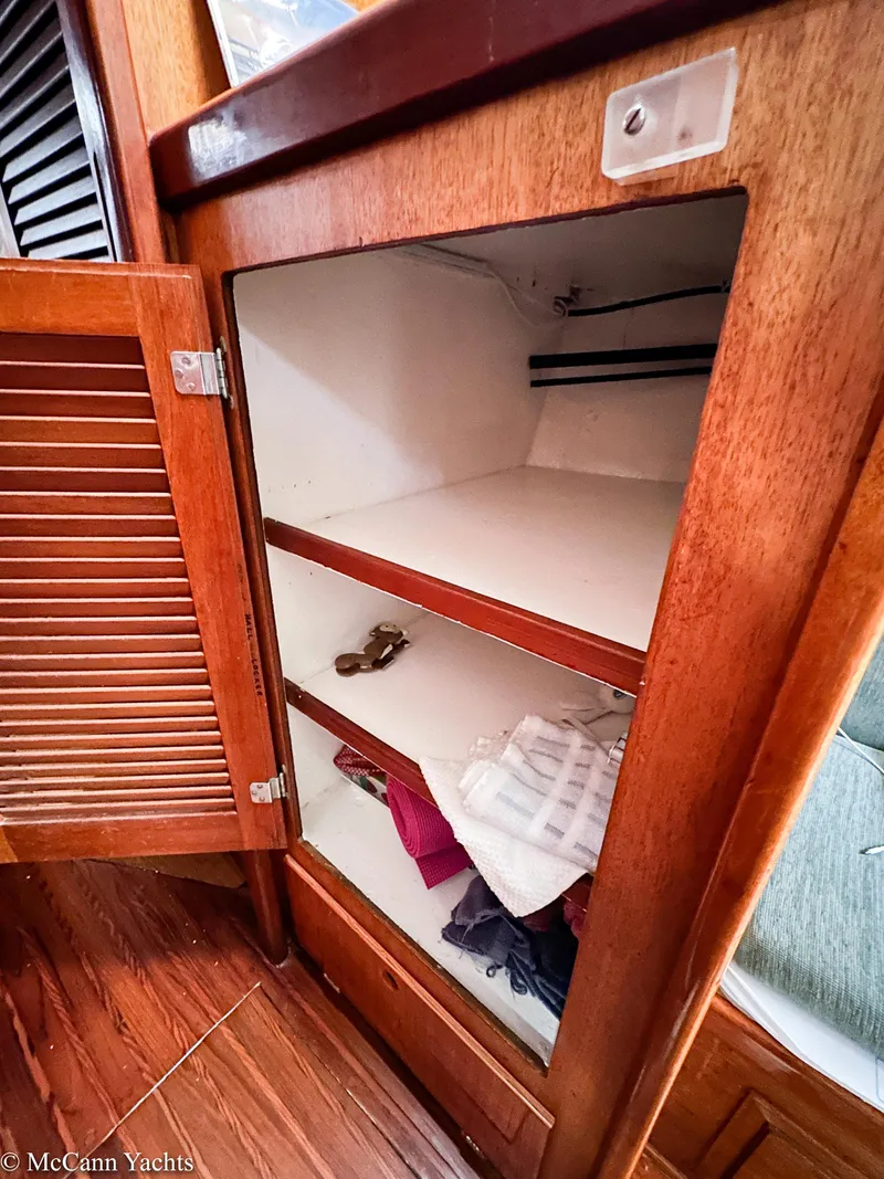 Slide: The Image of Open wooden cabinet with shelves inside a 1973 Challenger 40 yacht. - 33